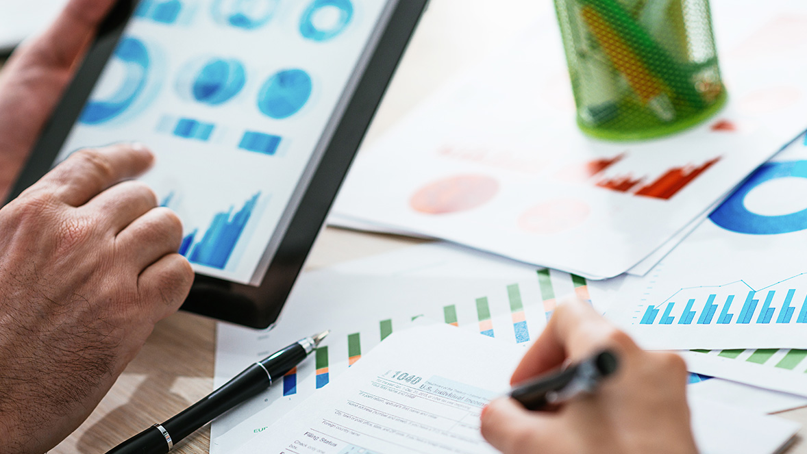 close up of hands using a tablet for graphs
