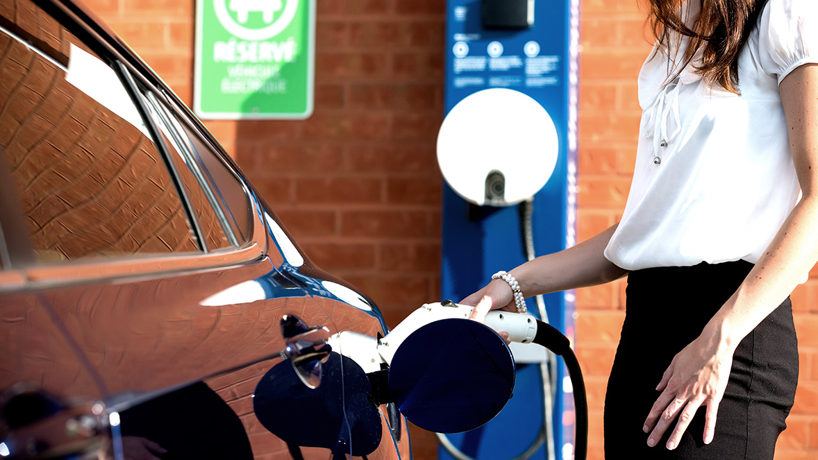woman charging her car at a charging point