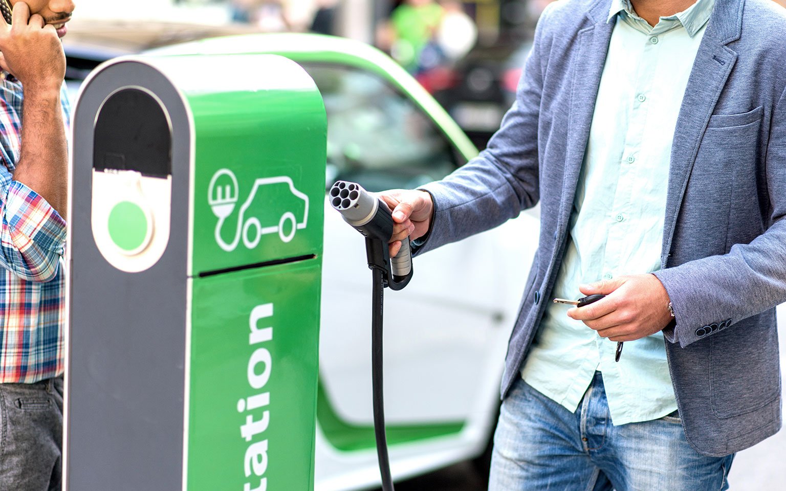 man charging electric car at chargepoint