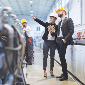 Por que usar menos papel? businessman and woman wearing hard hats on site
