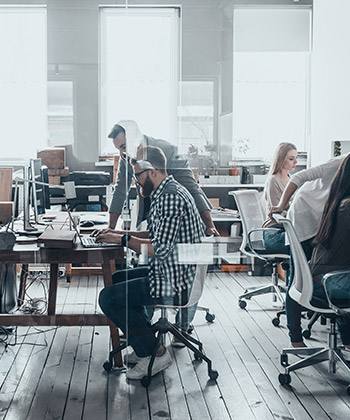 Um começo humilde employees working in a glass office