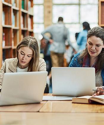 Be more sustainable people working at laptops in a library